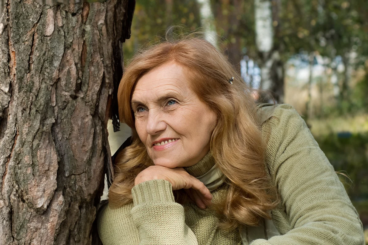 happy old woman posing in the park