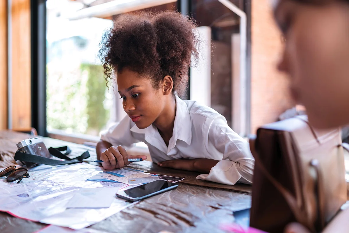 black girl focus looking on map plan.