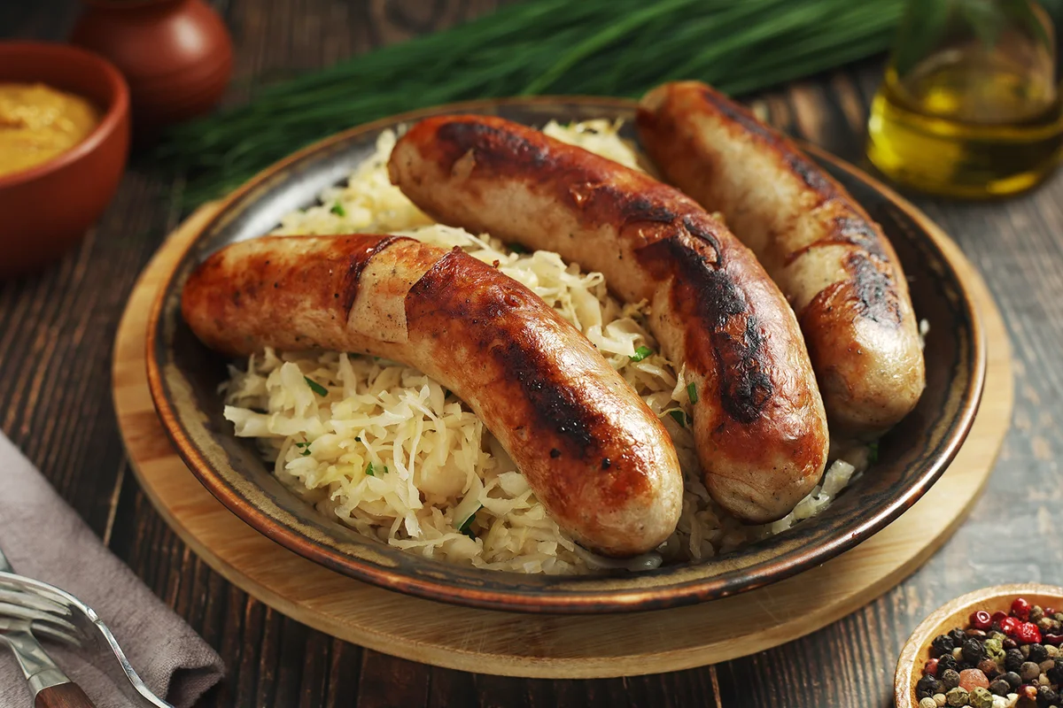 A bowl with Bratwurst and Sauerkraut as side dish