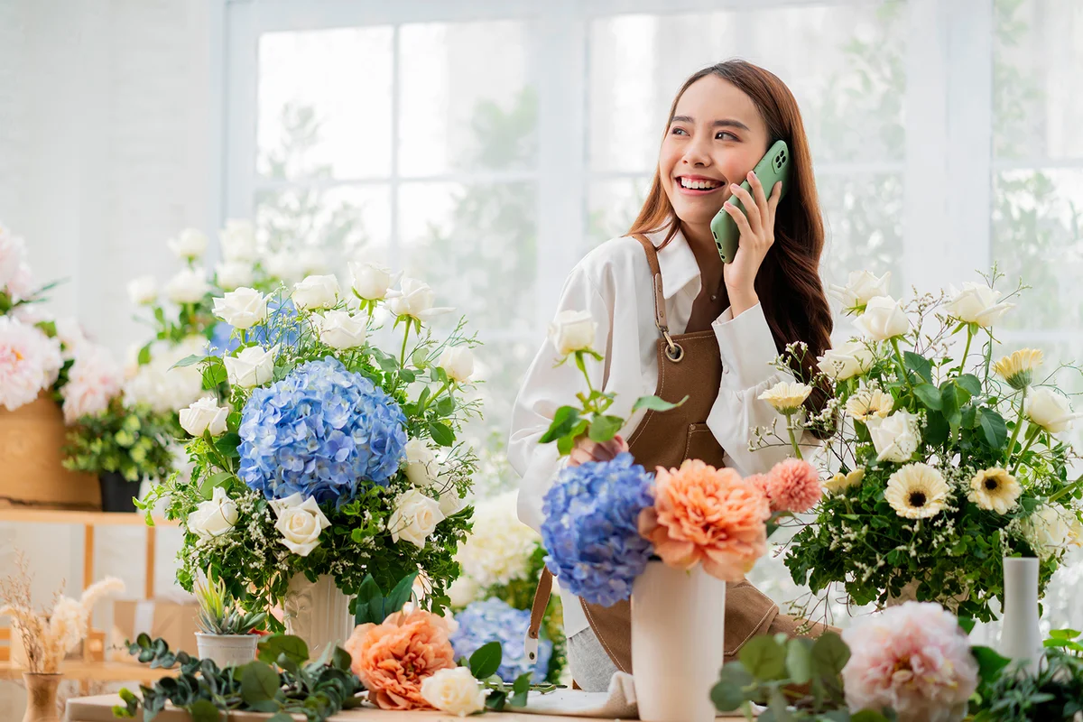 florist making list from client order to arrange flower bouqet vase delivery