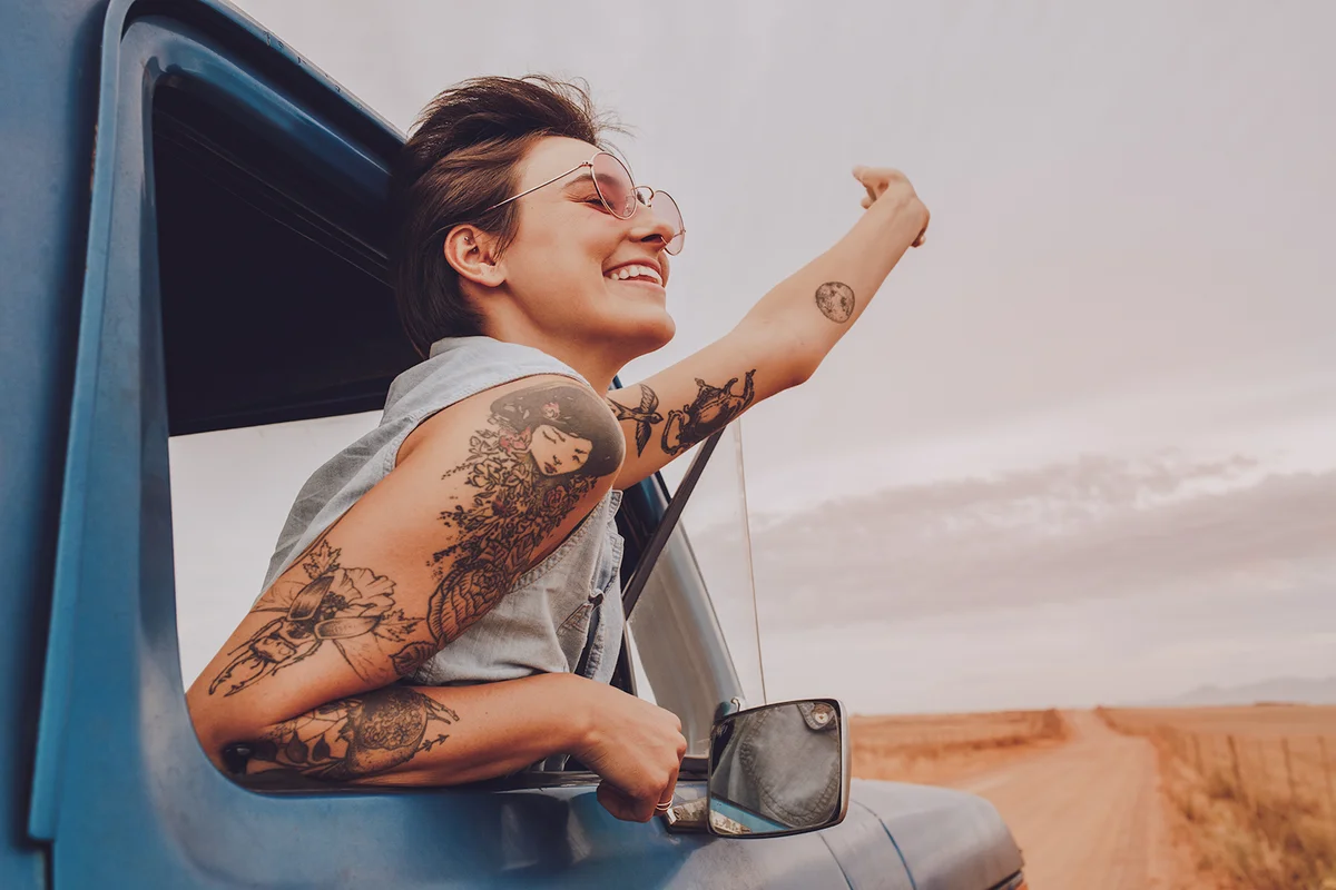 young woman enjoying road trip on a summer day