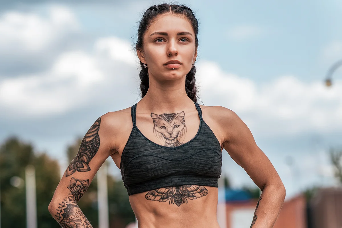 Woman with tattoo cats on chest