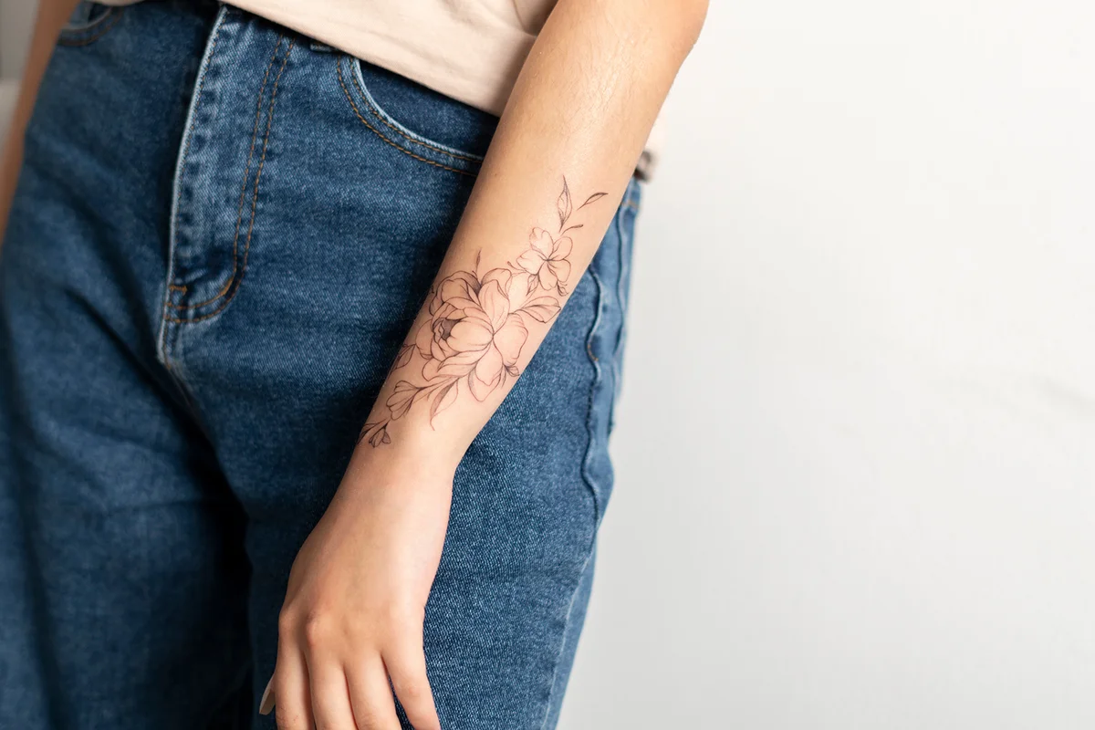woman showing her finished flowers tattoo on her hand
