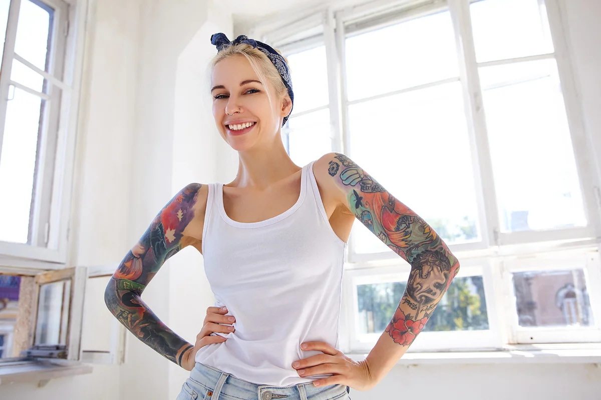 lovely tattooed blonde woman looking cheerfully at camera
