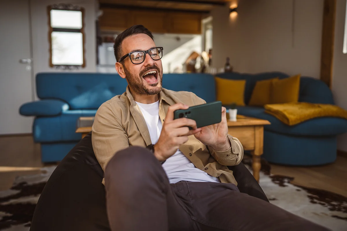 man play video games on his phone at home