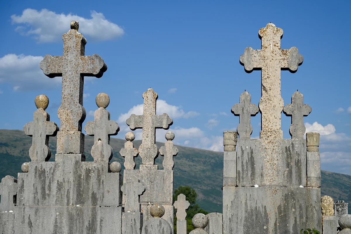 Old stone crosses in cemetery. Graveyard. Giant headstones.