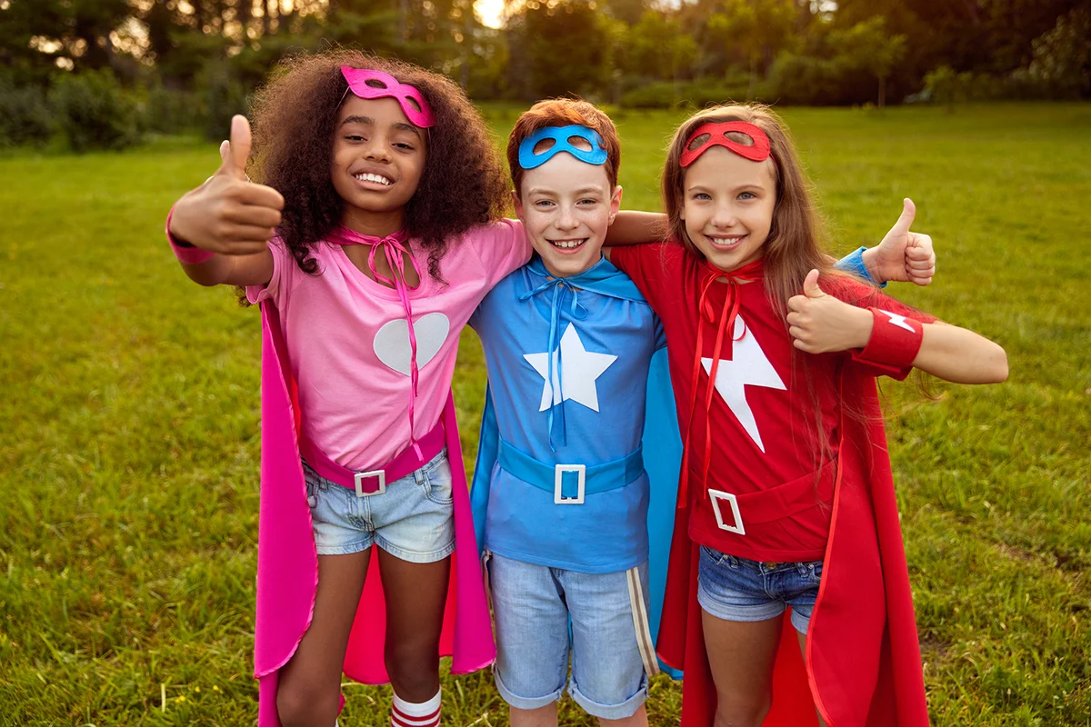 Group of multiracial friendly kids wearing superhero capes and masks