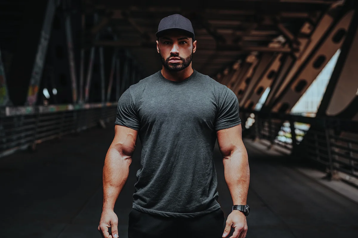 Young strong man bodybuilder posing on urban background
