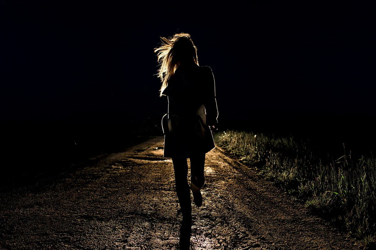 woman on an empty night road runs away