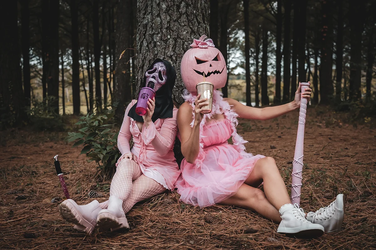 two girls posing together in jack o lantern and scream halloween costumes