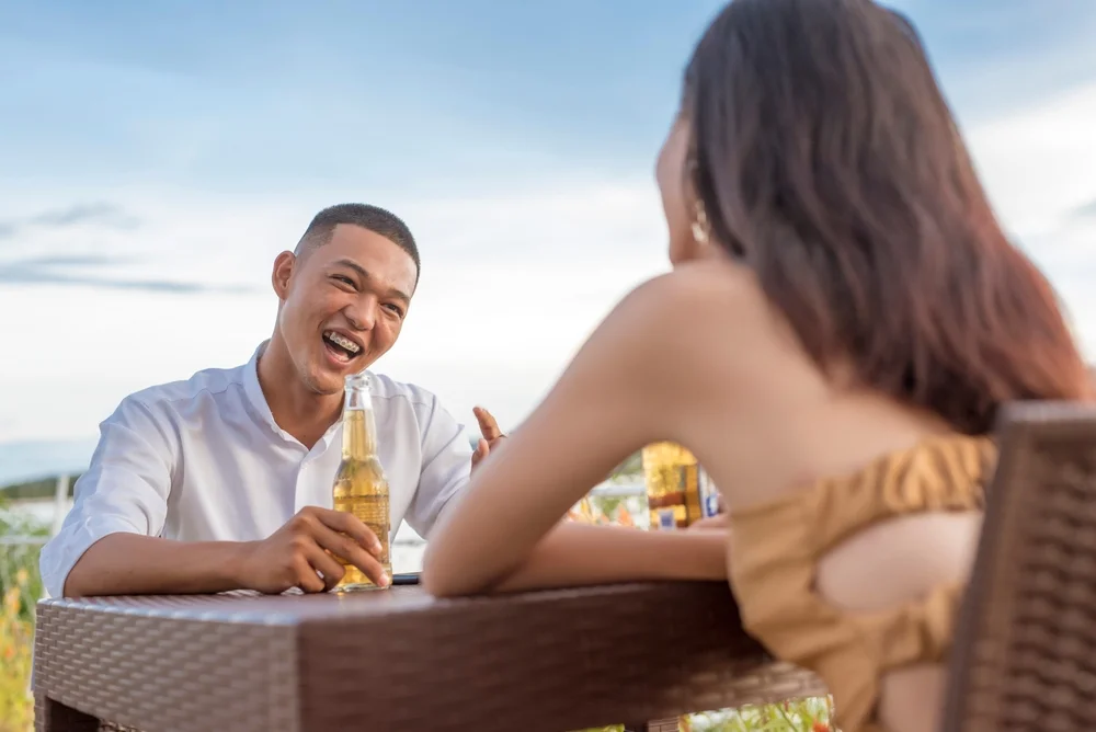 Man looking at a woman with admiration while having a great time at an outdoor cafe
