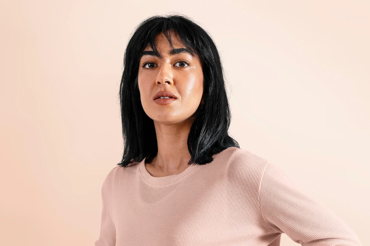 Black-haired woman in beige long sleeve