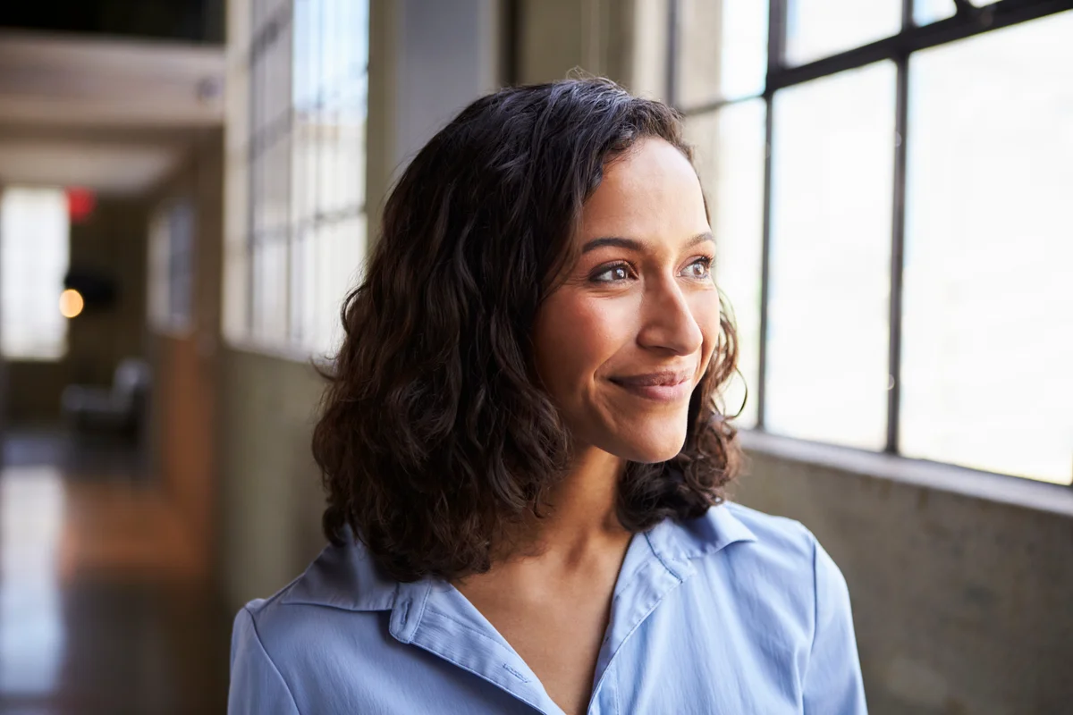 Smiling young mixed race businesswoman looking away