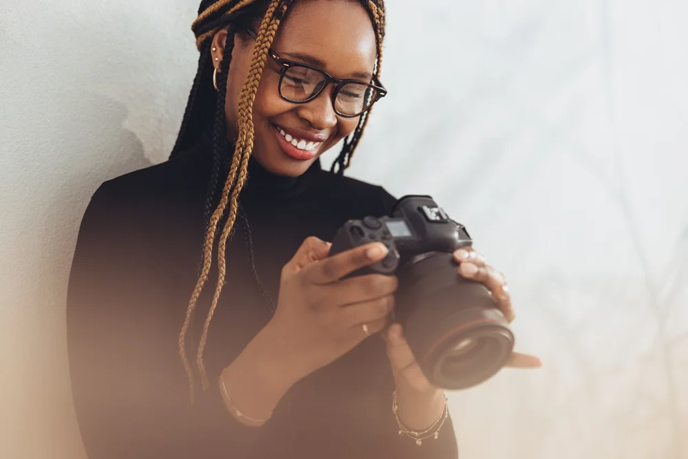 Passionate creative female holding a professional camera.