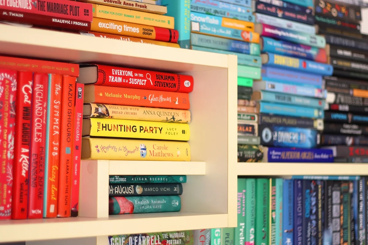 Bookshelf with books organized by rainbow colors