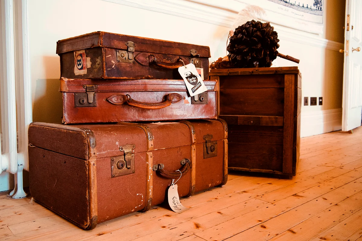 stack of three vintage leather suitcases on display