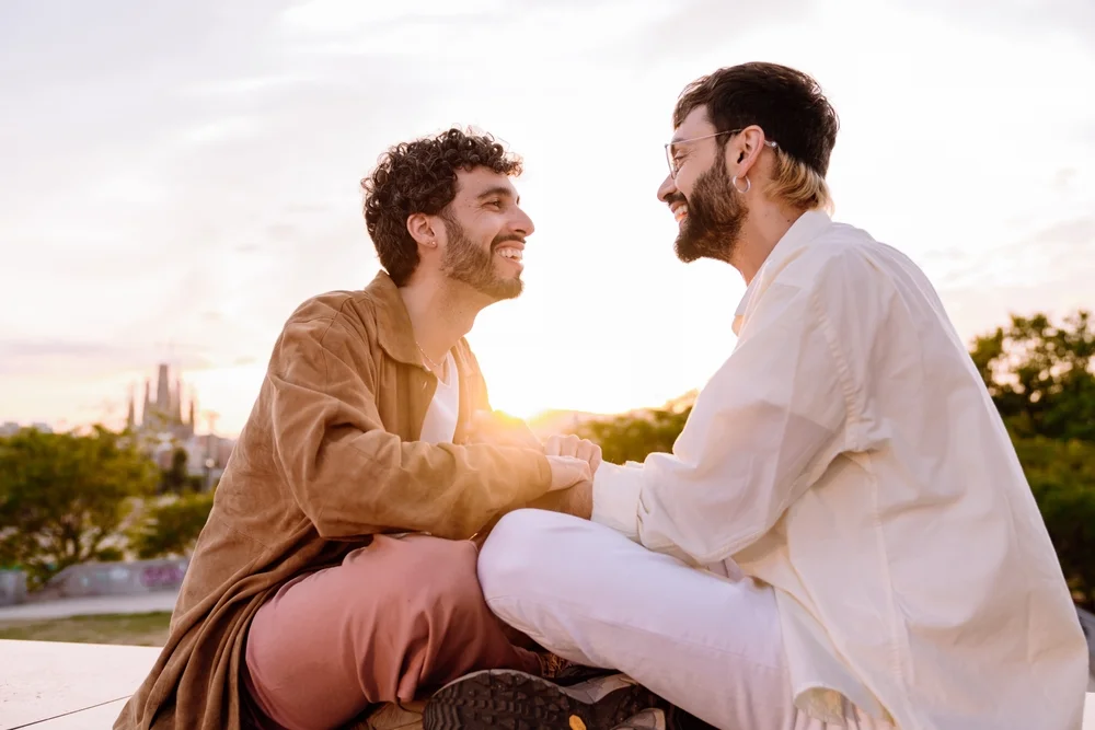Side view of cheerful young male couple looking at each other's romantically