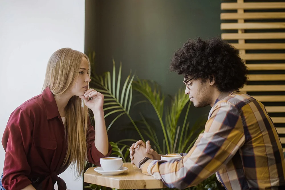 Upset man and woman sitting in silence in a cafe.