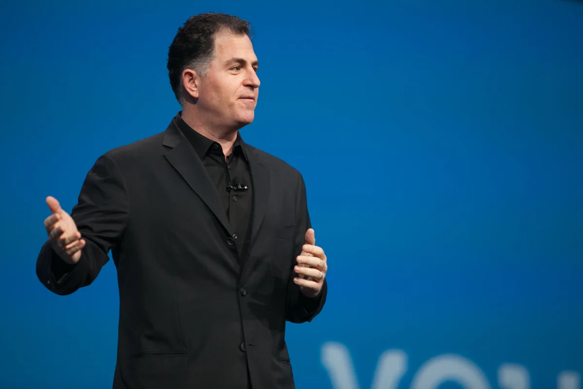 Photo of Michael Dell with a blue screen background speaking at an event.