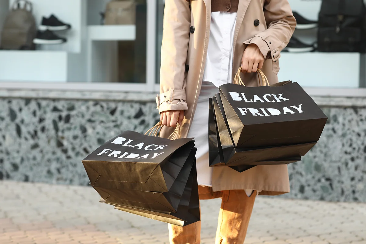 Beautiful young woman with shopping bags on city street