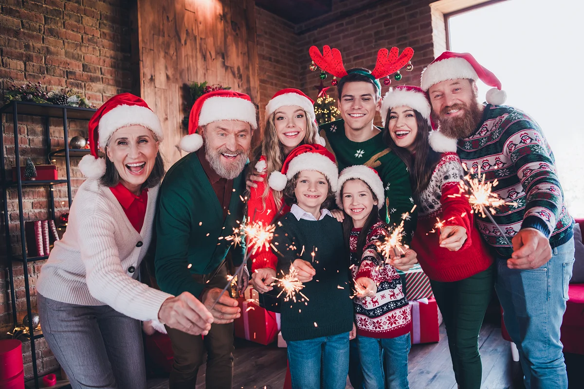 Portrait of family holding sparklers to celebrate christmas