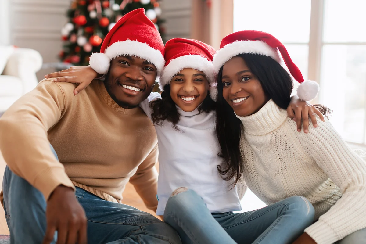 Portrait of cheerful family in red Santa Claus hats celebrating Christmas