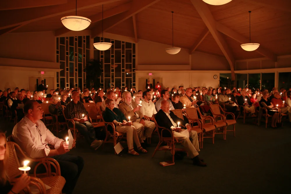 DELRAY BEACH, FLORIDA / USA - DECEMBER 24 2018: Parishoners in a congregation enjoy a candle-lighting ceremony in honor of the birth of Jesus Christ on Christmas eve.