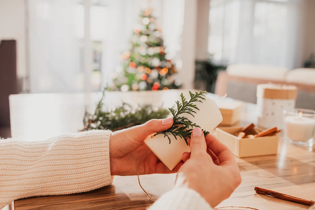woman's hands decorating candles for Christmas