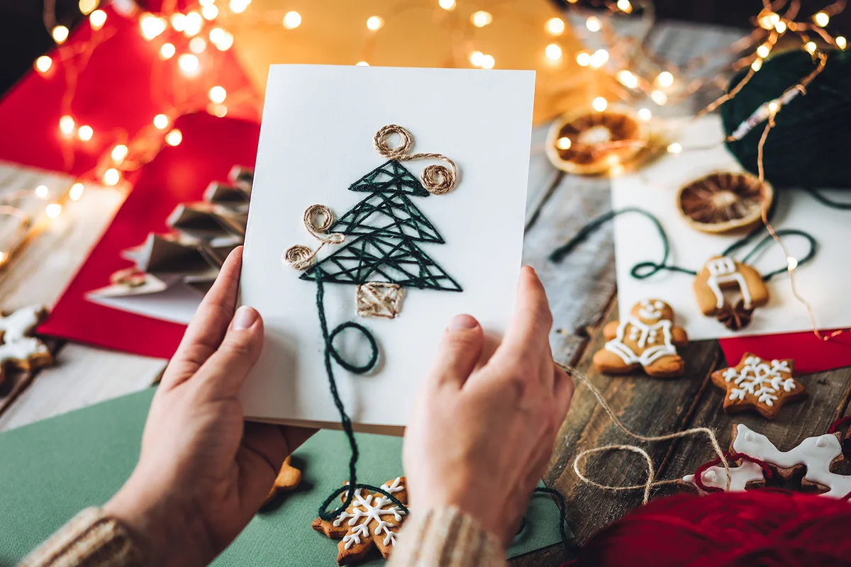 handmade Christmas card with wool thread embroidering on the craft recycled paper