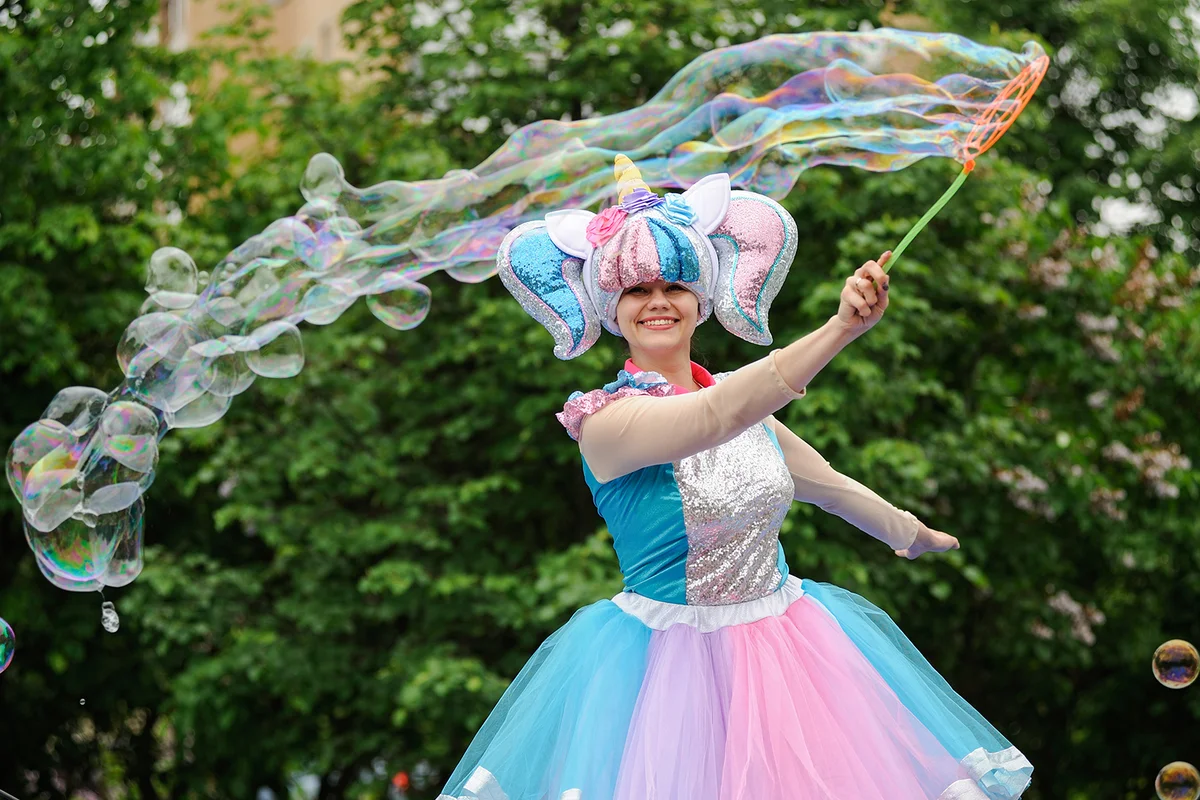 Smiling woman in bright unicorn costume