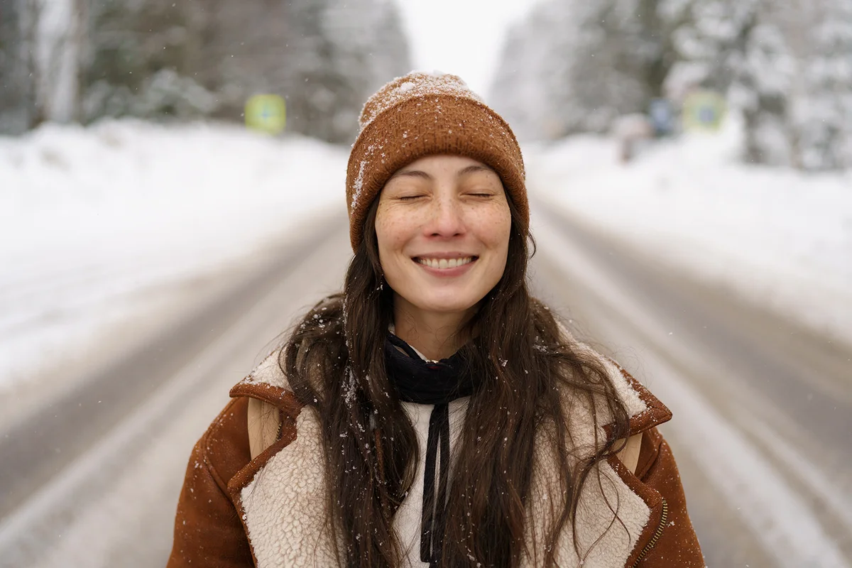 girl happy laughing during walk in snowy pine forest