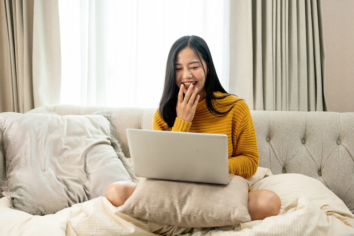 woman is laughing while watching a movie