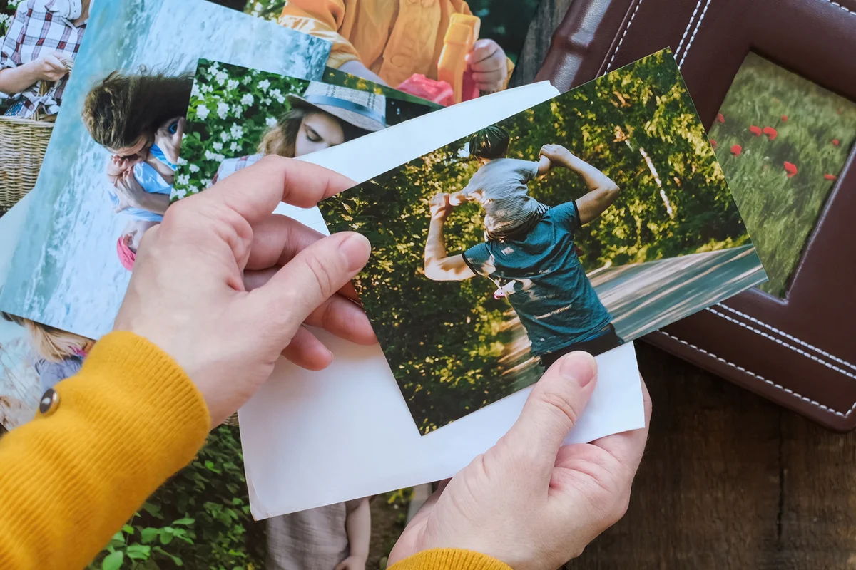 Person looks at printed photos for family photo album