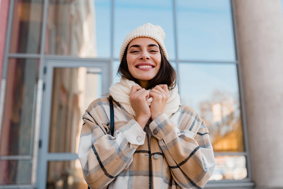 young smiling woman walking in street in winter outfit