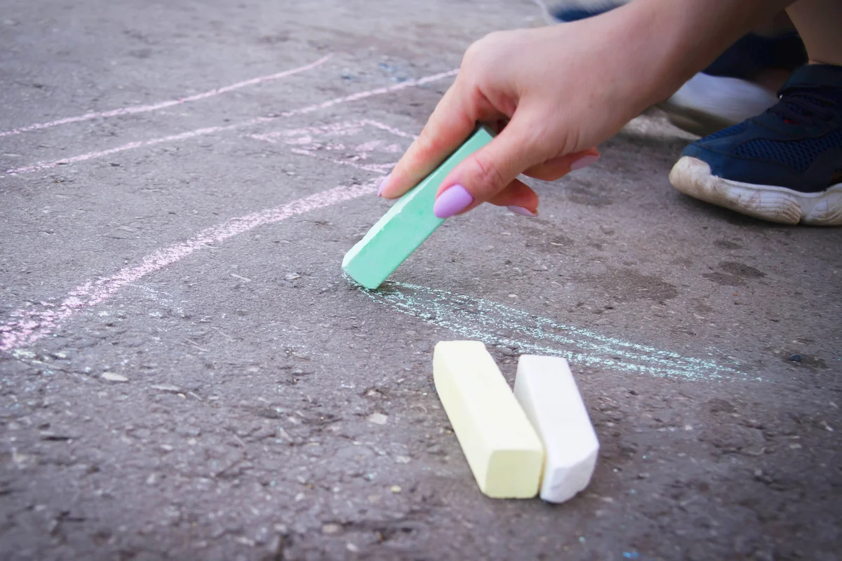 Woman drawing with chalk on the floor