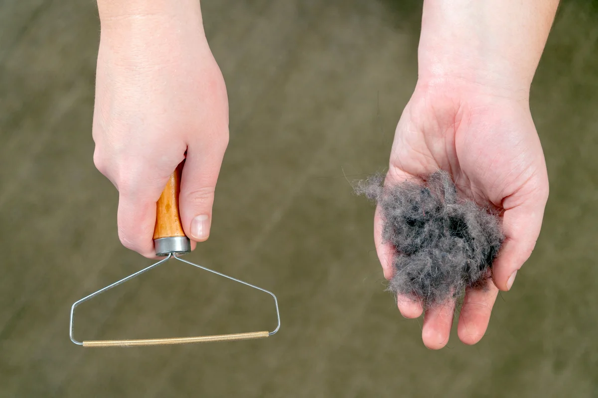 Hand holding dust ball and an uproot cleaner