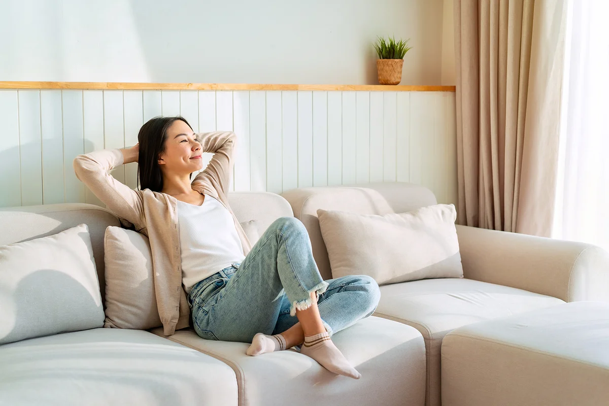 woman relaxing and sitting on a sofa at home in the morning