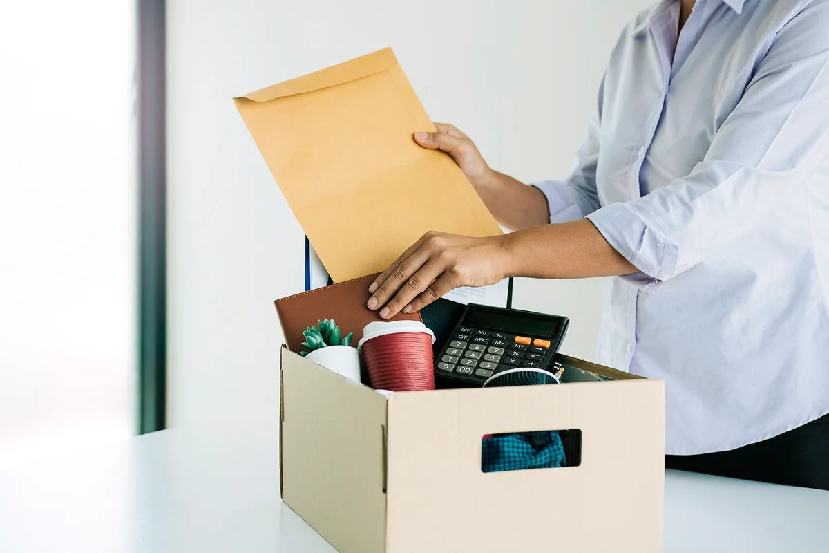 Woman employees are keeping their own items on the desk because they are about to go to resign with the manager.