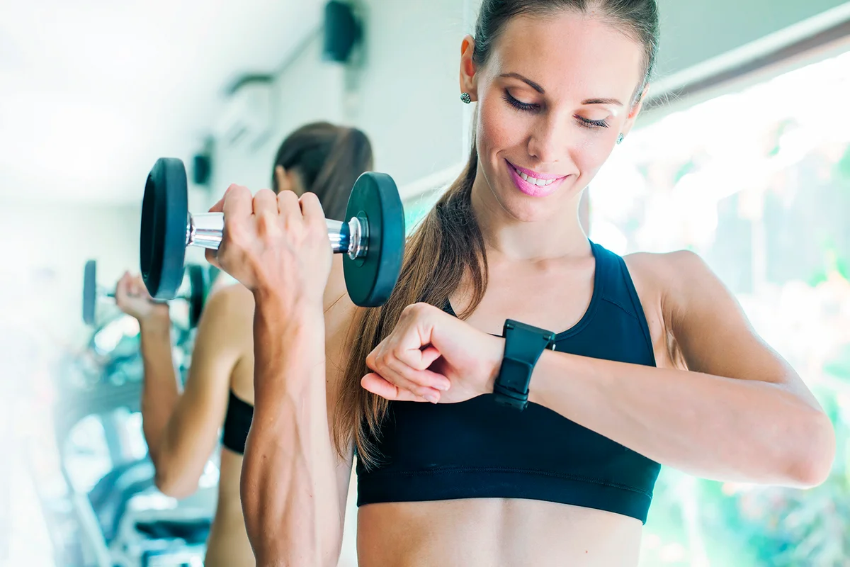 Smart watch showing a heart rate of exercising woman in gym