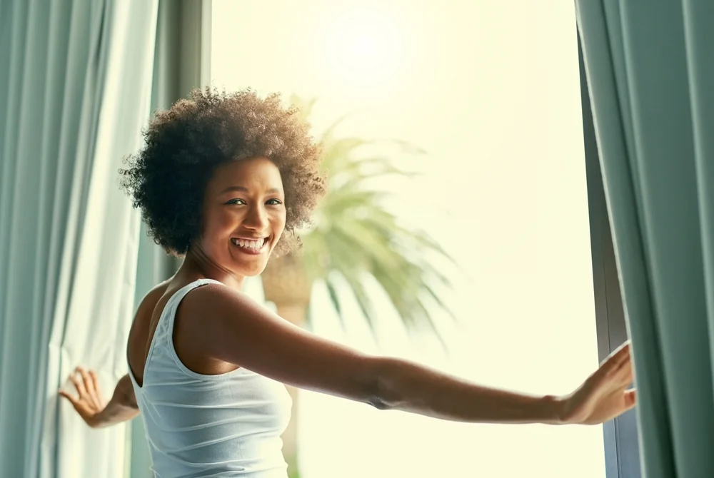 woman opening the curtains