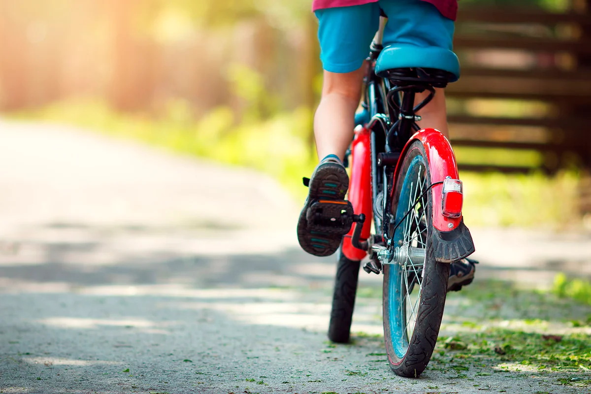 child on a bicycle at asphalt road in early morning