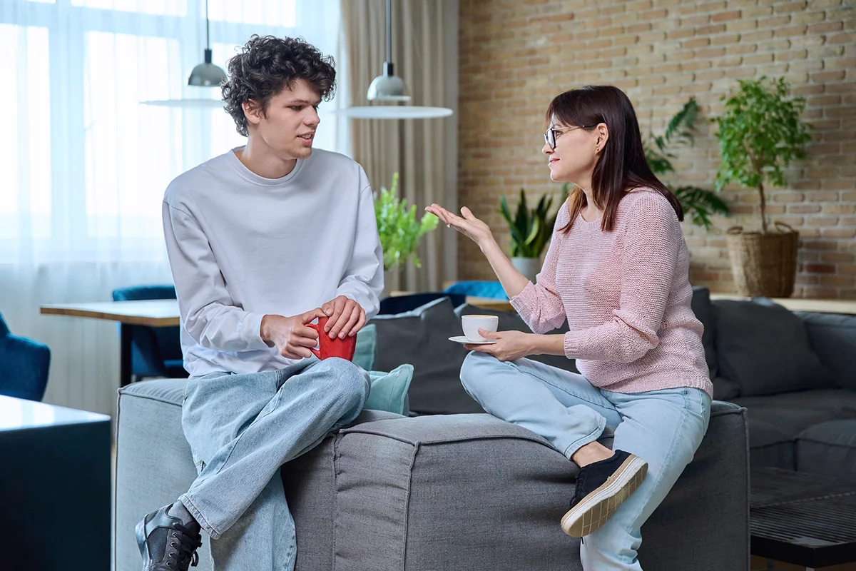 Middle aged mother and son 19, 20 years old talking together at hom