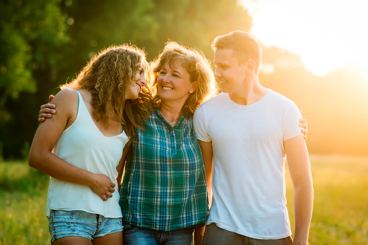 Cheerful happy caucasian family outdoors during summer sunset
