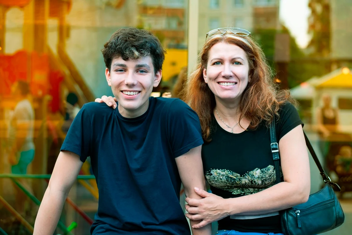 Boy of adolescence with his mother talk, laugh, have fun together all evening at sunset in the summer. Family summer time