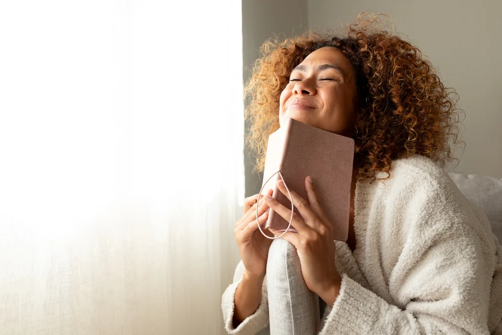 woman with journal smiling