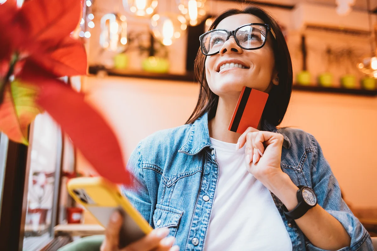 Dreamy young woman makes online purchases