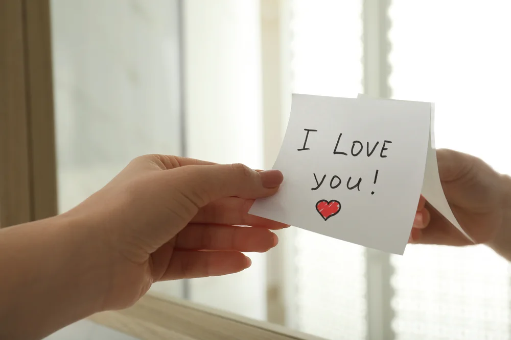 woman's hand putting a sticky note on the mirror