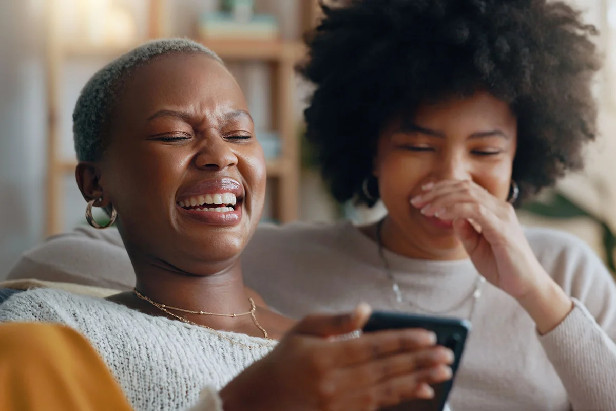 Women laughing watching their phone