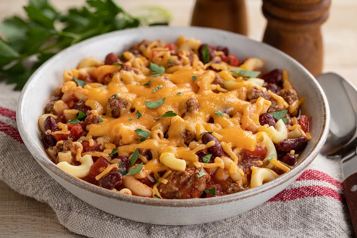 bowl of chili macaroni with melted cheddar cheese