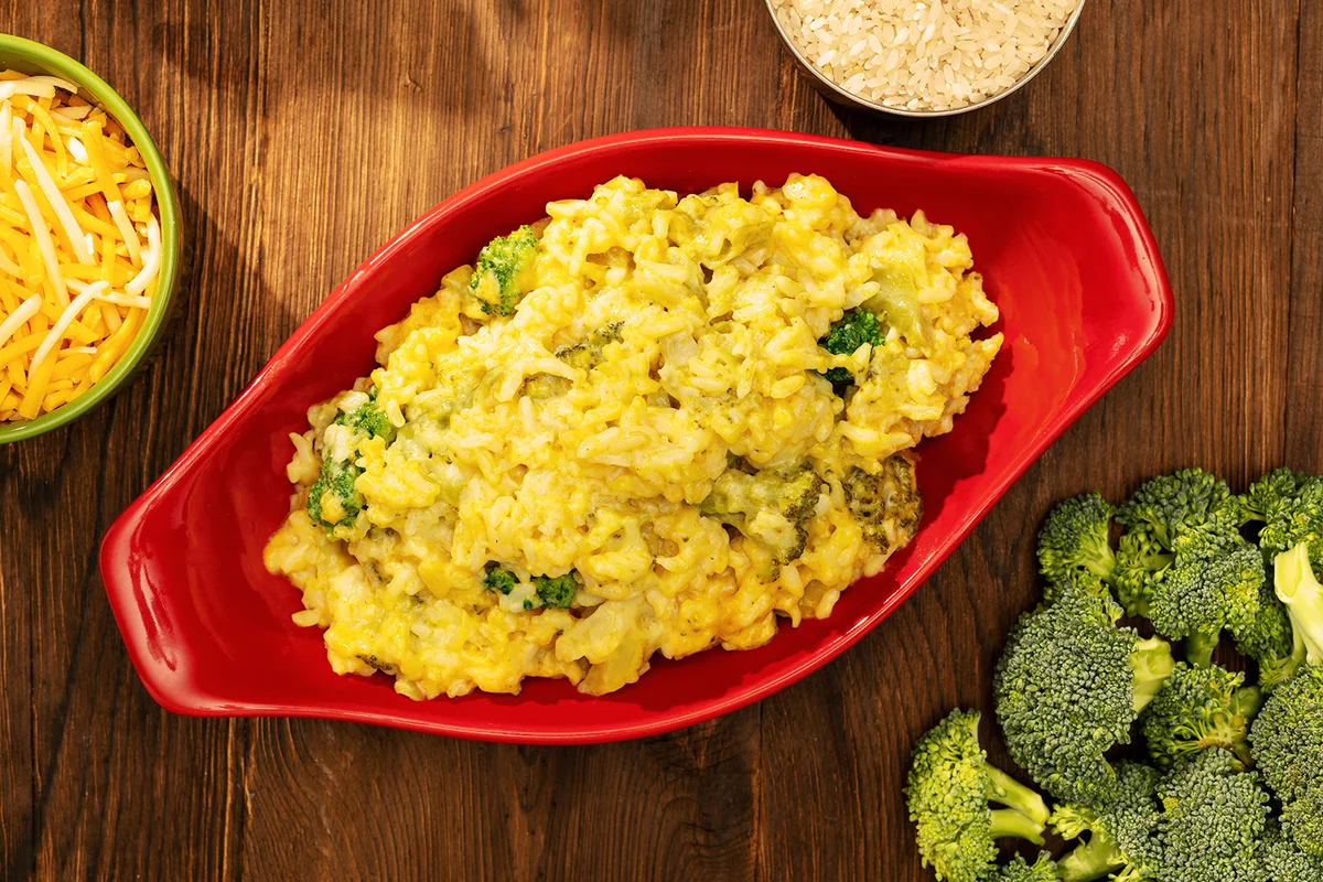 Broccoli and Rice Casserole on rustic wooden table with broccoli and cheese